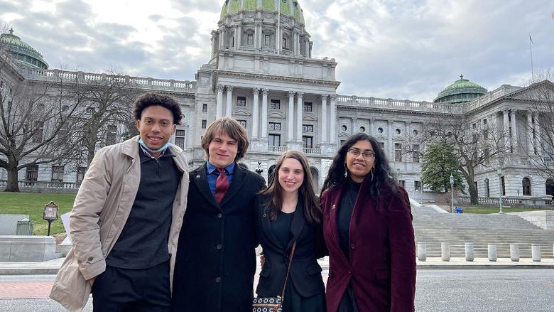 四个学生站在宾夕法尼亚国会大厦前